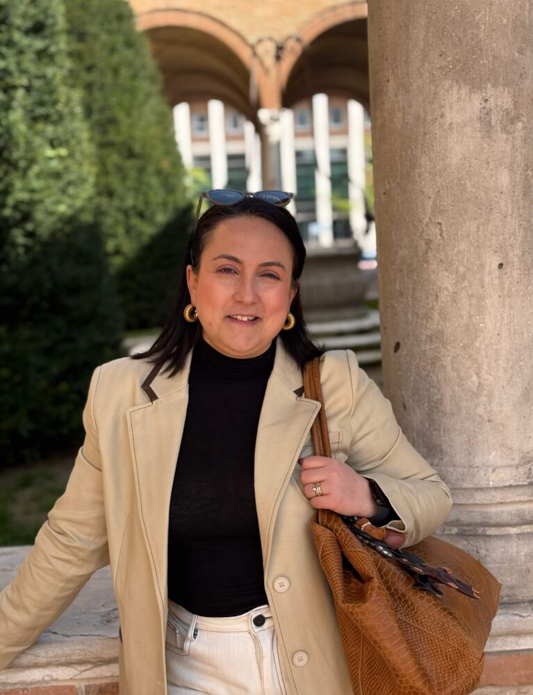 Alessandra con elegante giacca lunga e borsa